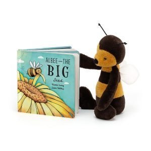 A cuddly Jellycat Bumble Bee looking at a hardbacked book which is also from Jellycat and is called Albee the Big Bee.