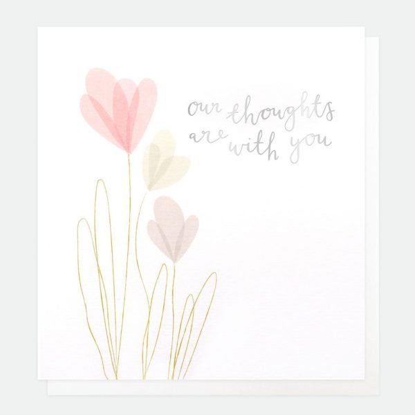 A white card with embossed flowers and gold foiling and the words 'Our thoughts are with you' printed on it.