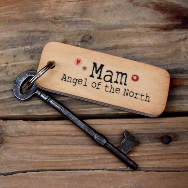 A wooden oblong rustic keyring with the words 'Mam Angel of the North' printed on it with little hearts around it.