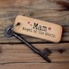 A wooden oblong rustic keyring with the words 'Mam Angel of the North' printed on it with little hearts around it.