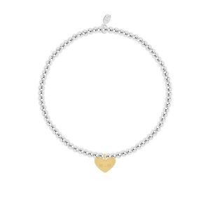 A silver plated bead stretch bracelet with an embellished gold heart charm from Joma Jewellery. The bracelet is presented on a pink coloured card with the wording A Little Mum in a Million printed on it.