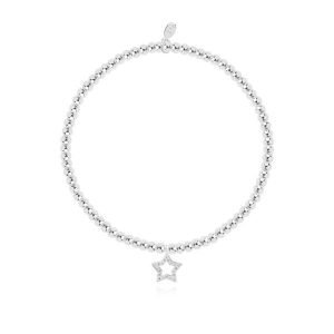 A silver plated elasticated bracelet with an embellished star on a square sentiment card with the words Happy Birthday. The card has confetti design all over it from jewellery company Joma.