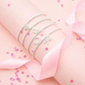 A silver plated elasticated bracelet with an embellished bow charm on it. The bracelet is on a lovely sentiment card with a confetti design all over it. The words A Little Thank You are printed on the card. From Joma Jewellery