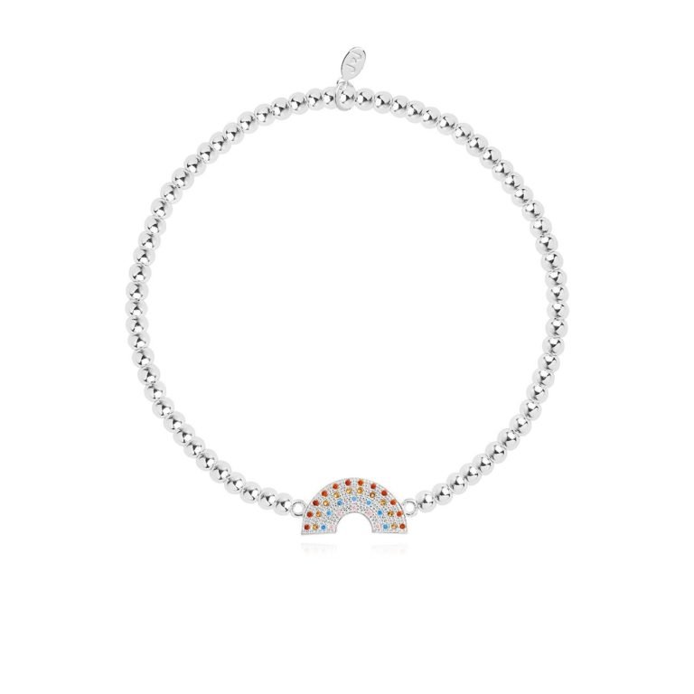 A silver plated stretch bracelet with a lovely colourful rainbow charm, from jewellery designer Joma. The bracelet is presented on a square card with the wording A Little Be Kind printed on it.