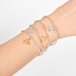 A silver plated bead stretch bracelet with a silver star with crystal on it from Joma Jewellery. The bracelet is presented on a pink square card with gold hearts on it.
