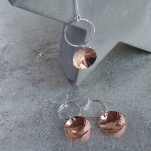 Necklace and earring set. Silver circle hoop with a copper hammered disc suspended from it.