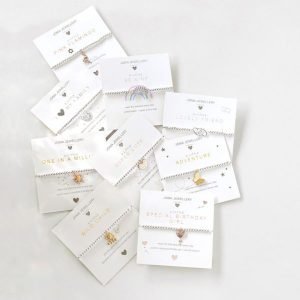 A silver plated elasticated bracelet with a gold plated heart balloon charm on a square sentiment card with the words A Little Special Birthday Girl'. The card has a gold heart balloon design on it and is a smaller size thatn the standard bracelets so is perfect for a child. From jewellery company Joma.