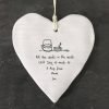 A white ceramic heart with a hanging cord printed with a drawing of a teapot and cup and the words All the words in the world can't say as much as a hug from Mum can
