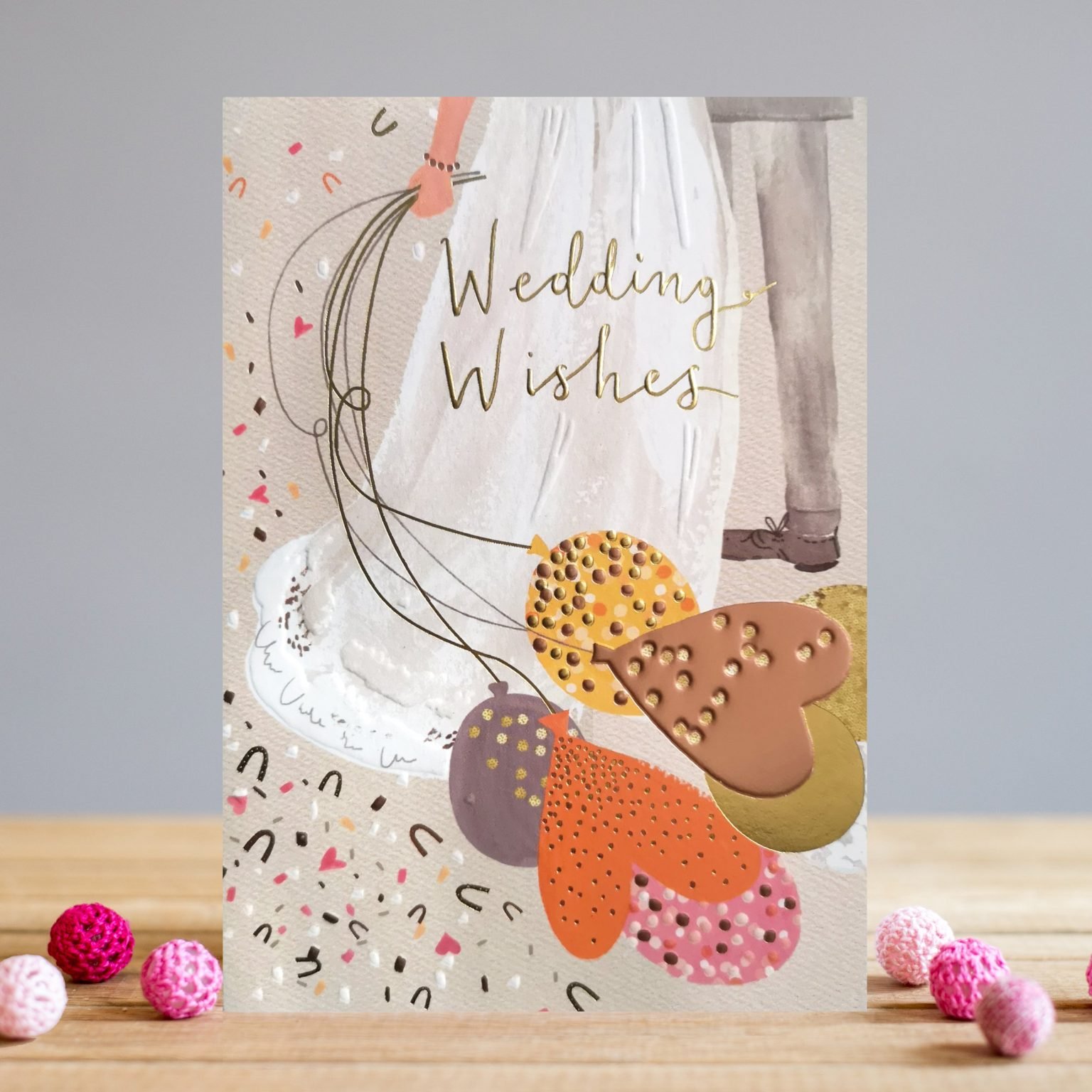 A beautiful card from Louise Tiler. The image is of a couple on their wedding day. The bride with a long flowing dress is holding some balloons and there is a confetti effect all over the card.