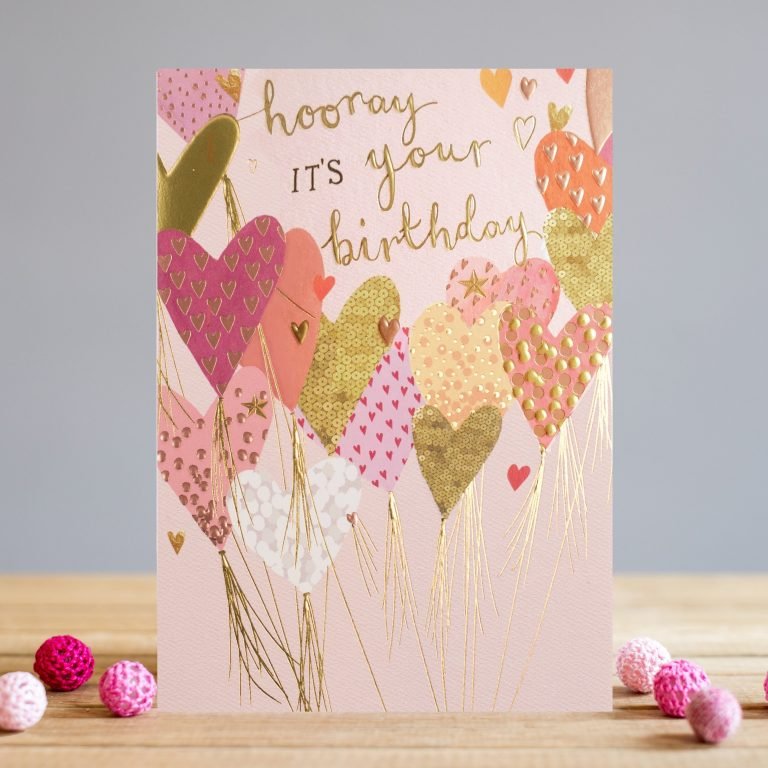 A card from Louise Tiler with a pale pink background and with colourful heart balloons all over it, with the words Hooray on Your Birthday embossed foiled and printed on it.