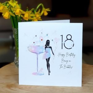 A shimmering white card with a beautiful rainbow illustration of a woman in silhouette wearing a party dress in front of a big cocktail glass. hand finished with genuine crystals. 18 Happy Birthday Bring on the Bubbles