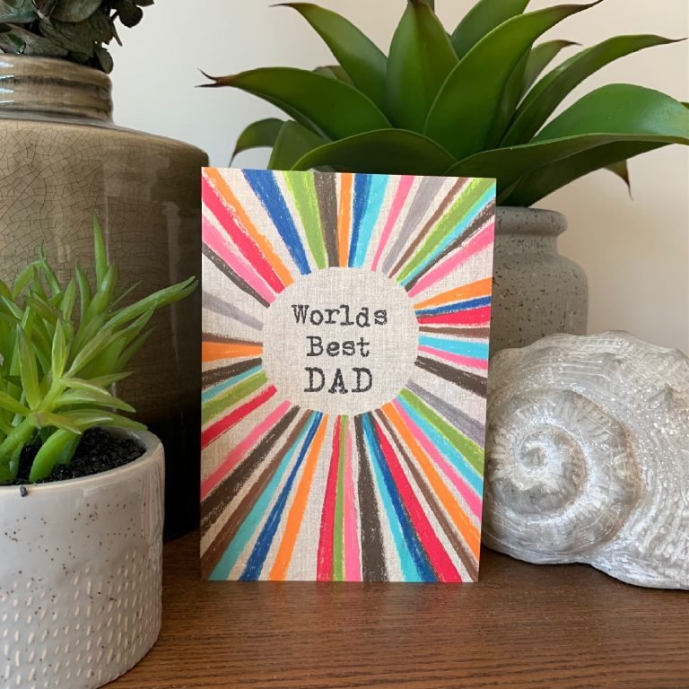 A multi coloured rainbow card with the words World's Best Dad printed in the centre of it.