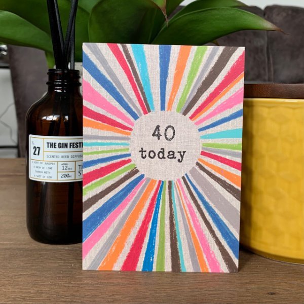 A multi coloured rainbow card with the words 40 today printed in the centre of it.