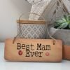 A rustic wooden hanging sign with the words Best Mam Ever printed on it.