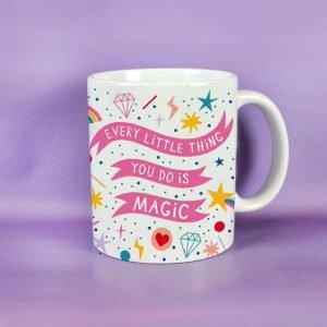 A colourful mug with the words Magic Mum printed on it and rainbows and stars all over it. on the back of the mug are the words 'Every little thing you do is magic'.