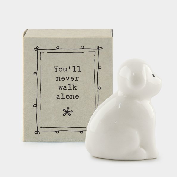 A sweet little ceramic dog keepsake in a little matchbox with the words You'll never walk alone' printed on it