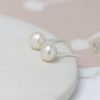 A pair of white freshwater pearl earrings with sterling silver posts and backs.