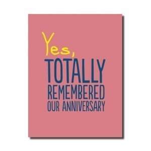 A pink card that says Yes, totally remembered our anniversary in yellow and black
