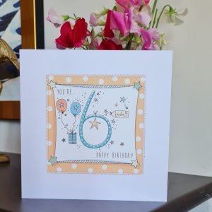 A 6th birthday card. A white card with an orange spotty square stitched on to the card with a colourful hand drawn 6, little hand drawn stars and a present with balloons. You're 6 today Happy Birthday