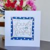 A card to congratulate You've passed your driving test card. A white card with a square of navy blue polka dot paper stitched on to it with a further white square with a hand illustration of the words You've Passed decorated with a little blue car and hand drawn stars. Great news You've Passed