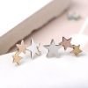 A pair of sterling silver triple star studs that have two of the stars plated in rose gold and yellow gold.