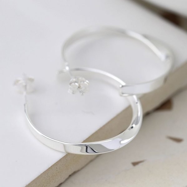 A pair of sterling silver hoop sleeper earrings which have a twist effect.