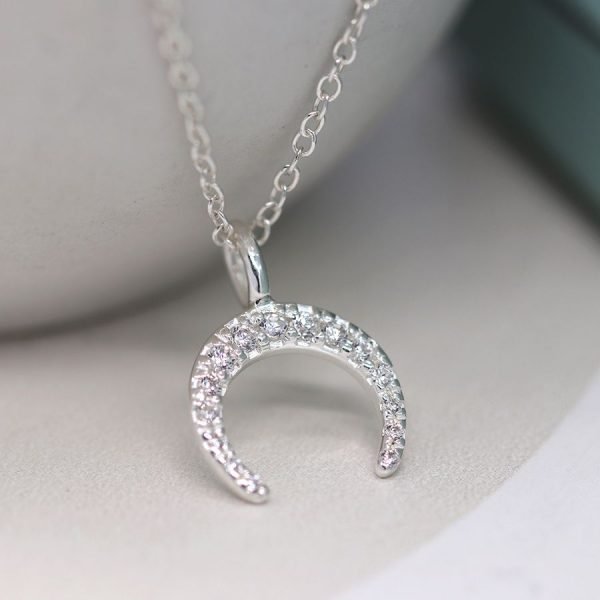 A lovely inverted crescent moon shaped charm that is covered in cubic zirconia crystals on a fine chain.