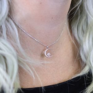 A beautiful moon and starburst charm necklace which is covered in cubic zirconia crystals on a 16 inch silver chain.