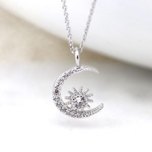 A beautiful moon and starburst charm necklace which is covered in cubic zirconia crystals on a 16 inch silver chain.