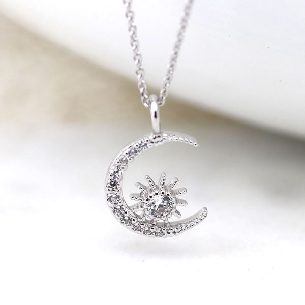 A beautiful moon and starburst charm necklace which is covered in cubic zirconia crystals on a 16 inch silver chain.