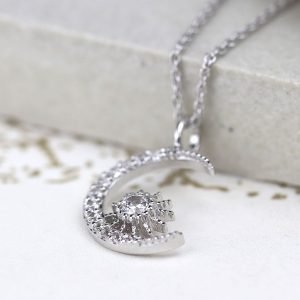 A beautiful moon and starburst charm necklace which is covered in cubic zirconia crystals on a 16 inch silver chain.