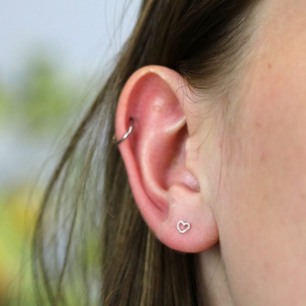 A pair of sweet tiny cutout heart stud earrings made from sterling silver