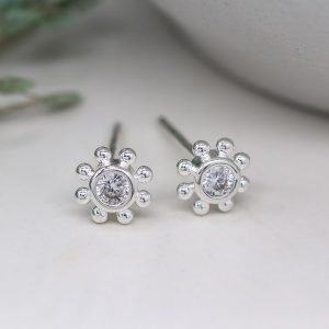 A lovely pair of flower style stud earrings with a faceted cubic zirconia centre and fancy edging made from sterling silver.