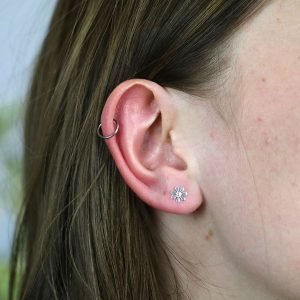 A sweet pair of sterling silver daisy stud earrings with a seven petal design