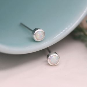A lovely pair of sterling silver round stud earrings with an iridescent opal setting.