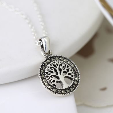 A lovely silver tree of life charm which has marcasite gemstones all the way around it.