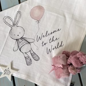A sweet square pink bunny welcome muslin to give as a gift for a new baby girl. The image is of a bunny holding a pink balloon with the words Welcome to the World printed on it.