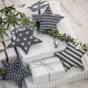 An assortment of grey and white patterned star hanging christmas decorations with ribbon hangers