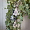 An assortment of tree shaped christmas decorations. Each one has a different pattern in grey and cream