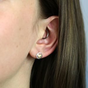 Framed gold heart stud earrings. A small gold plated heart framed in a sterling silver circle