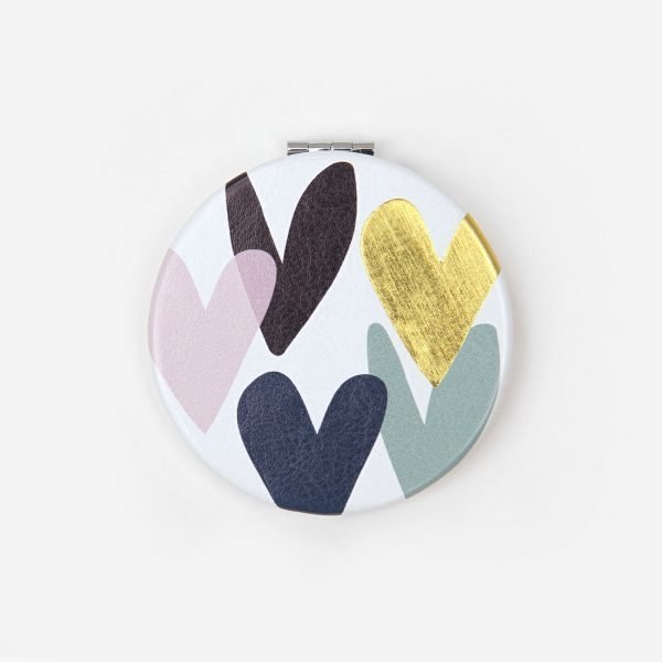 Falling Hearts Pocket Mirror. A handy little round hinged pocket mirror. The cover has a hearts design in grey, pink and gold. One of the mirrors is magnifying