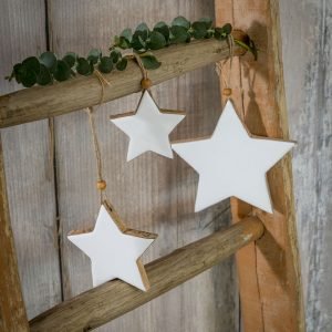A chunky wooden hanging star with a white enamel face and a rope twine to hang
