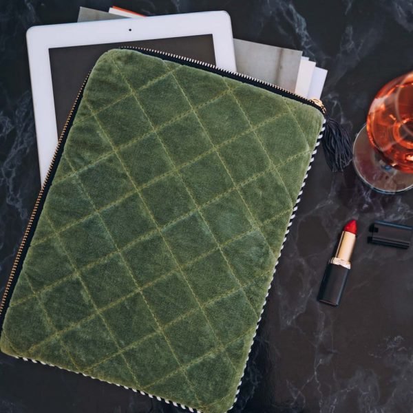 A quilted velvet tablet cover with internal padding, a zip fastening and tassel.