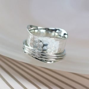 A sterling silver hammered textured wide ring with 3 wavy thin smooth silver spinning bands