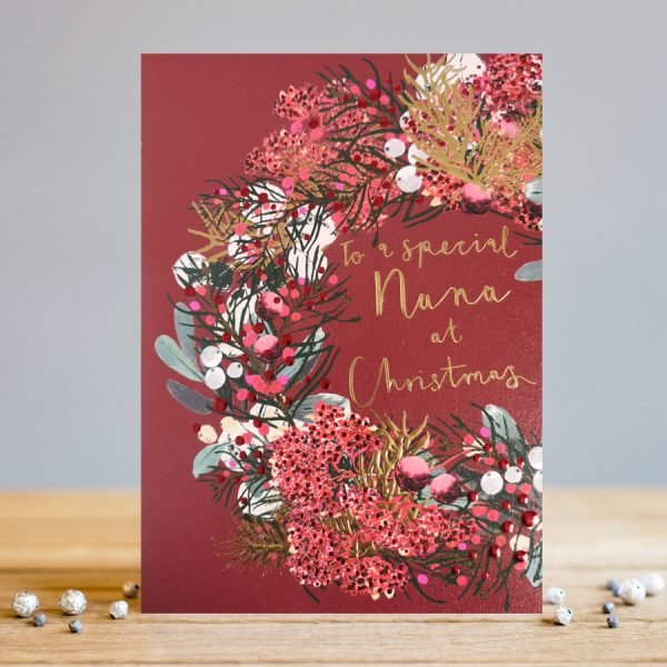 A lovely christmas card with a dark red background and an image of a wreath on it. The words to a Special Nana at Christmas are printed in the centre of the wreath.