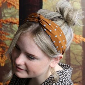 A lovely headband that is covered with a ginger and blue polkadot material.