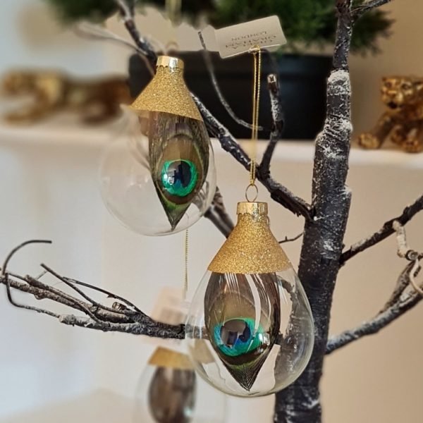 A clear glass bauble with a real peacock feather inside topped with gold glitter