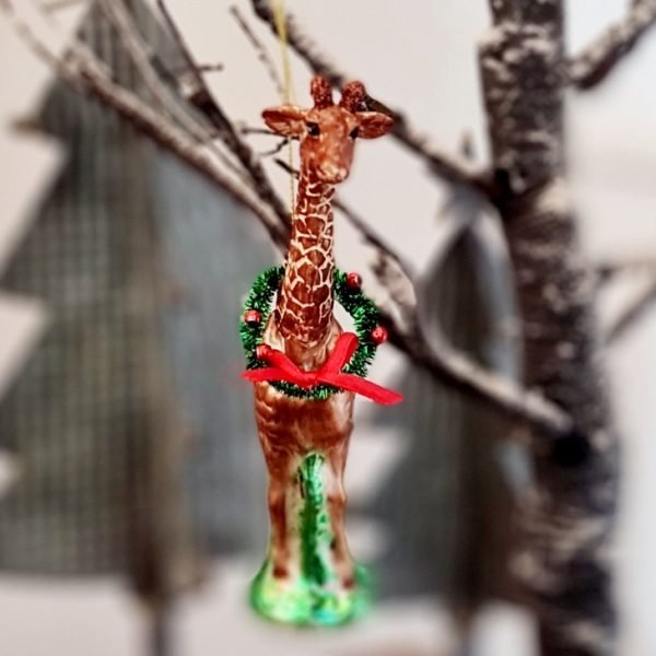 A glass and resin giraffe decoration. With a glass body and resin neck and head this beautiful decoration has beautiful glitter highlights and a Christmas wreath around its neck