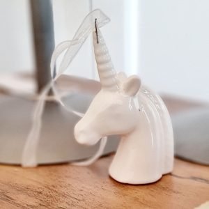 A white porcelain unicorn head with an organza hanging ribbon. An elegant Christmas decoration