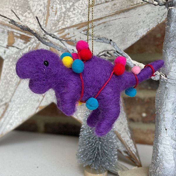 A purple T-rex felt hanging decoration with pompoms all over it.